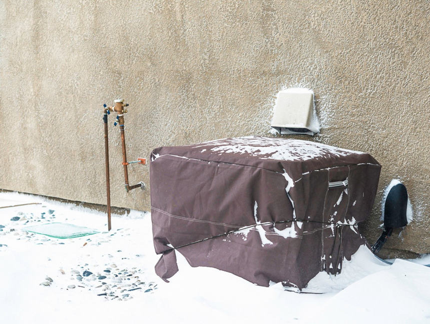 An outdoor air conditioning unit covered for winter protection by Above & Beyond Heating and Air Conditioning in Iowa City, IA.