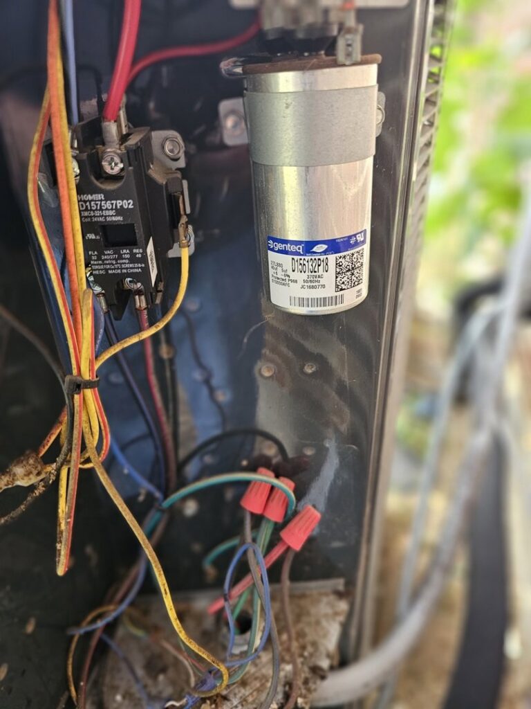 A close-up view of an outdoor AC unit's electrical components, including a capacitor and wiring, serviced by MasterCraft Mechanical, LLC. in Haslet, TX.