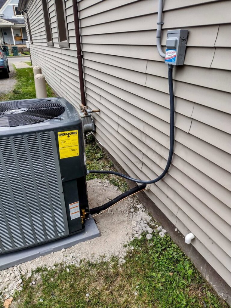 An outdoor AC unit with electrical connections installed by Total Comfort Heat and Air Conditioning, Inc. in Rochester, NY.