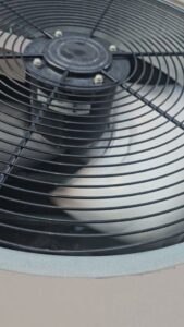 A close-up view of an outdoor AC unit's fan, showcasing HVAC equipment by Henry Refrigeration & Hvac Utah in Ogden, UT.