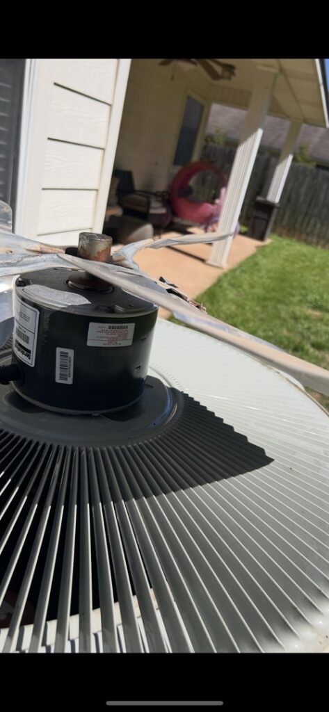A close-up view of an outdoor AC unit's fan and motor during an inspection or repair by Air Advisors of Louisiana in Shreveport, LA.