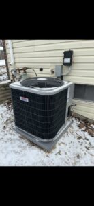 An outdoor air conditioning unit surrounded by snow, maintained by Holzer Heating And Cooling in Savage, MN