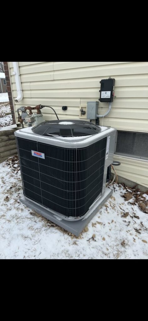 An outdoor air conditioning unit surrounded by snow, maintained by Holzer Heating And Cooling in Savage, MN