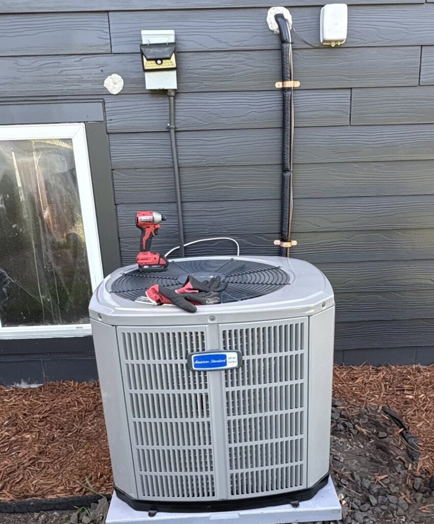 An outdoor American Standard AC unit with tools, indicating installation or service by A&E Heating & Cooling in Fort Worth, TX.