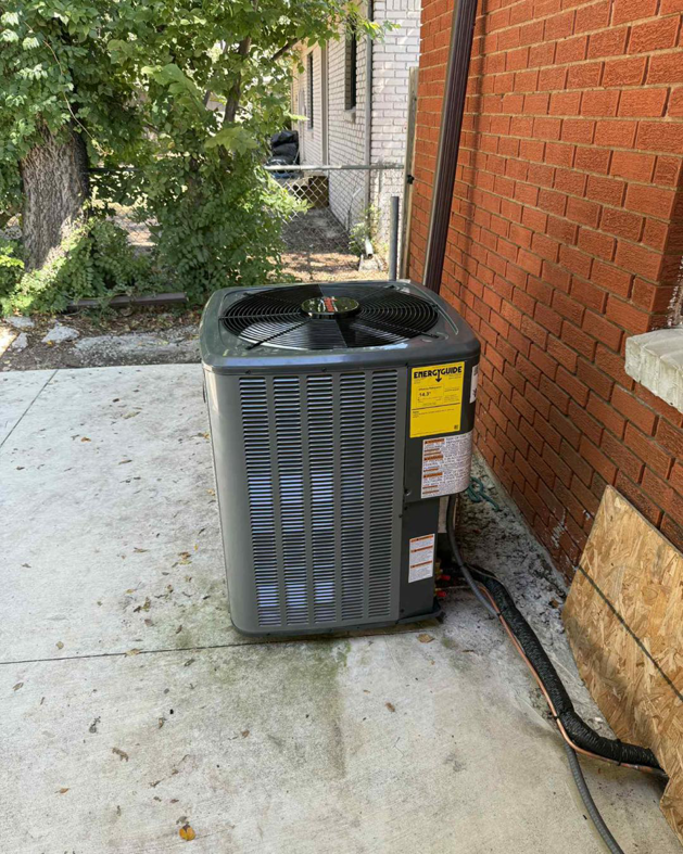 An outdoor air conditioning unit installed next to a brick wall by AirTech Solutions LLC in Broken Arrow, OK.