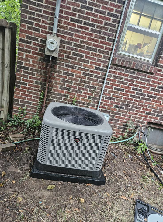An outdoor AC unit installed next to a brick building by Astron Services LLC in Wichita, KS.