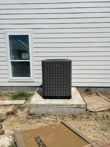 An outdoor Rheem AC unit installed next to a new house by Comfort Zone AC and Heating Services LLC in Sunrise Beach, MO