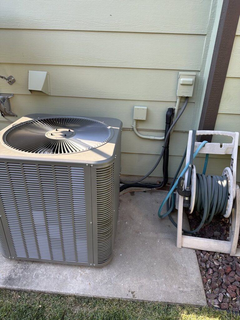 An outdoor AC unit recently installed next to a home by Great Plains Heating & Air in Goddard, KS.