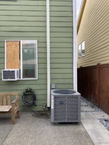 An outdoor Carrier air conditioning unit installed next to a home by Heatwave Heating & Air LLC in Federal Way, WA.