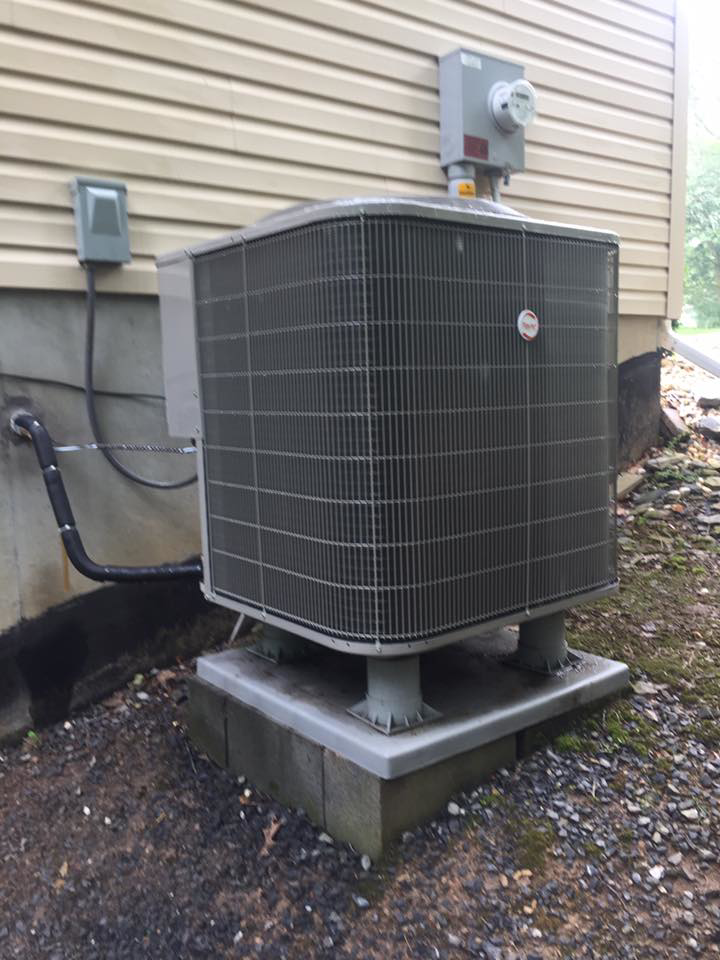 An outdoor air conditioning unit installed next to a residential building by Hitz Heating Inc. in Harrisburg, PA.