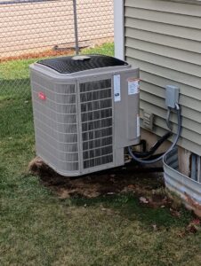 An outdoor AC unit installed next to a residential home by Kustom Heating & Cooling in Elgin, IL
