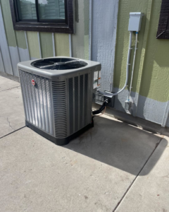 An outdoor air conditioning unit installed next to a home by Paul's Heating & Air Conditioning in Virginia Beach, VA.