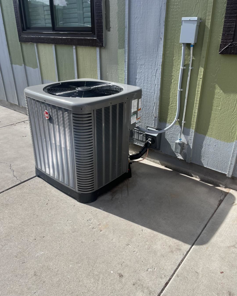 An outdoor air conditioning unit installed next to a home by Paul's Heating & Air Conditioning in Virginia Beach, VA.