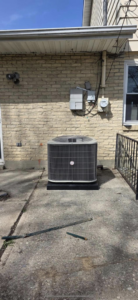 An outdoor AC unit installed next to a brick building by Pike Mechanical in Vevay, IN.