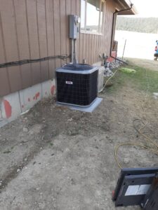 A newly installed outdoor air conditioning unit next to a residential building by Arrowseal of Billings HVAC in Billings, MT.