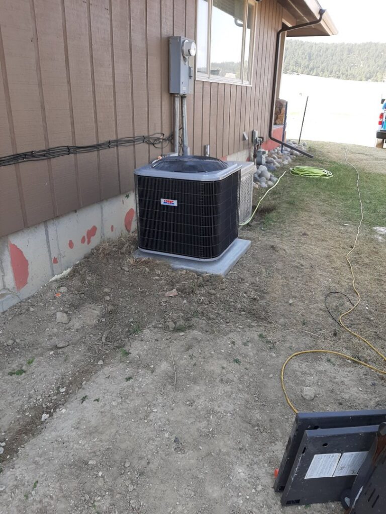 A newly installed outdoor air conditioning unit next to a residential building by Arrowseal of Billings HVAC in Billings, MT.