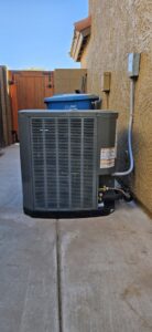 An outdoor AC unit recently installed next to a residential home by Ash Cooling & Heating in Mesa, AZ.