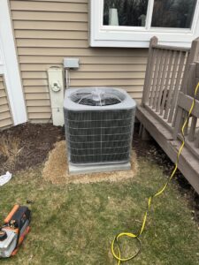 An outdoor air conditioning unit being installed or serviced next to a home by Service Champions Heating & Cooling in Aurora, IL.