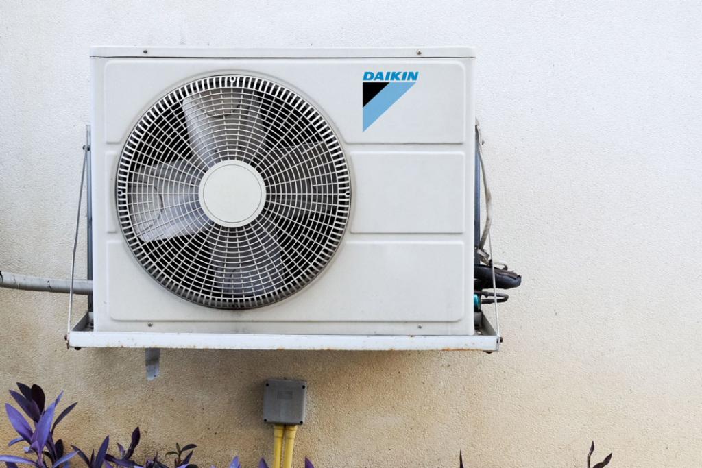 An outdoor Daikin air conditioning unit installed on a building wall by Service2.0 in Toledo, OH.