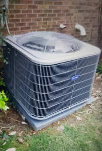 An outdoor Carrier air conditioning unit installed next to a brick wall by Temperature Comfort Heating and Cooling in Louisville, KY.