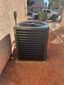 An outdoor air conditioning unit installed next to a residential building by Usa Air Conditioning & Heating in Las Vegas, NV