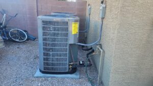 An outdoor AC unit newly installed next to a residential building by Vertex Heating & Cooling in Buckeye, AZ
