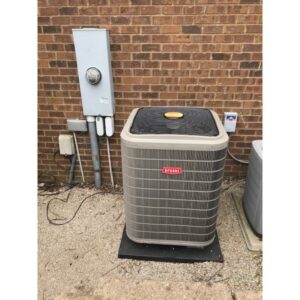 An outdoor Bryant air conditioning unit installed next to a brick building by Ware's Heating & Cooling in Georgetown, KY.