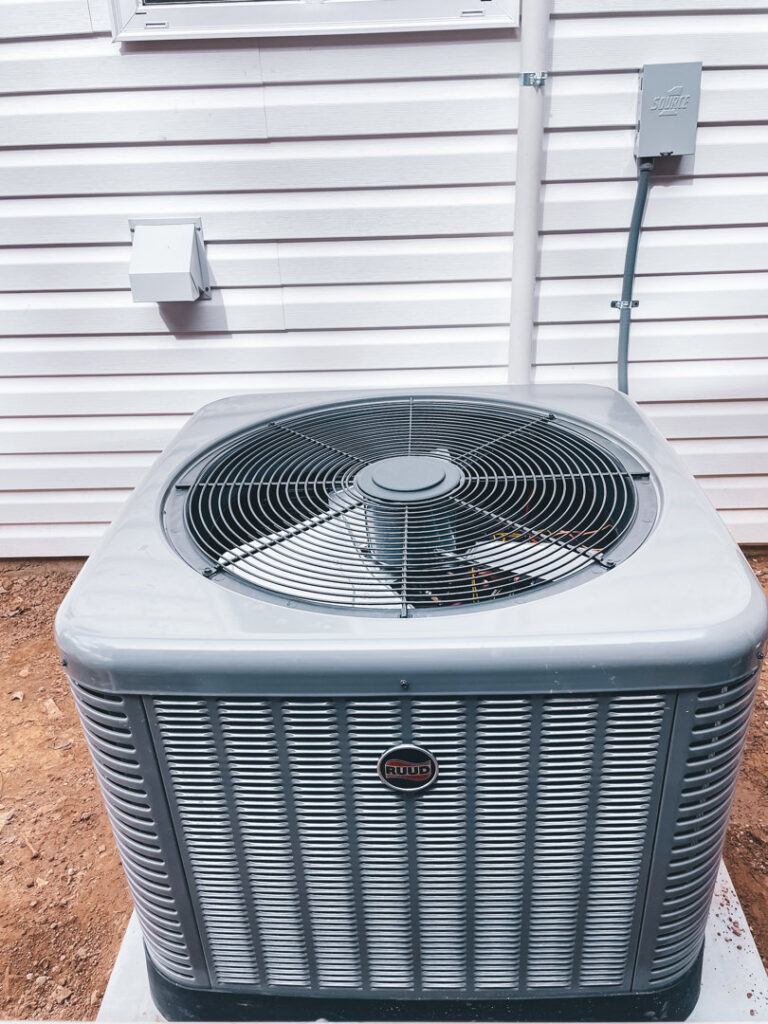 An outdoor air conditioning unit installed next to a residential building by A & A Air Conditioning & Heating in Little Rock, AR.