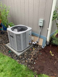 An outdoor air conditioning unit integrated with landscaping by Excellence Heating & Cooling, LLC. in Beaverton, OR.