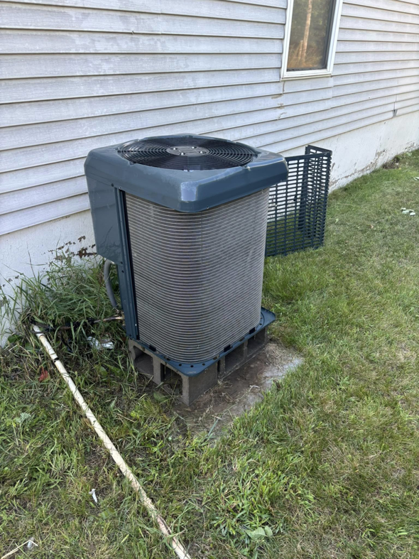 An outdoor air conditioning unit undergoing maintenance by Premier HVAC/ Small appliance in Brooklyn, NY.