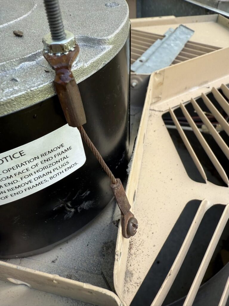 Close-up of the motor and fan assembly on top of an outdoor air conditioning unit, indicating an HVAC service by Greenley Heating & Cooling in Waterloo, IA