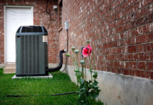 An outdoor air conditioning unit installed next to a brick house by HVAC Logistics in Albuquerque, NM