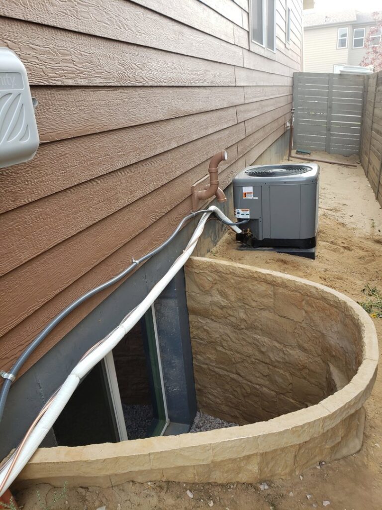 An outdoor air conditioning unit installed next to a residential house by Thin Air Heating & Cooling Repair in Arvada, CO.