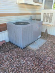 An outdoor AC unit installed next to a mobile home by Heating & Air Paramedics - Tucson in Tucson, AZ.