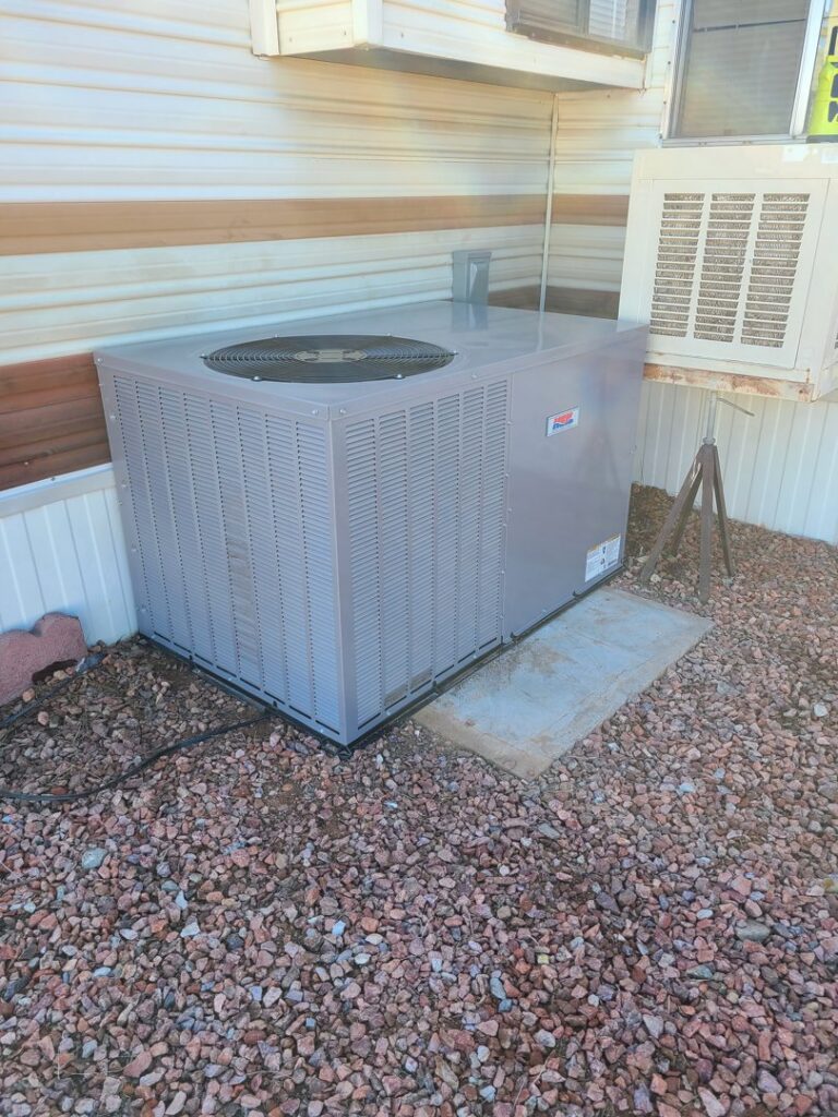 An outdoor AC unit installed next to a mobile home by Heating & Air Paramedics - Tucson in Tucson, AZ.