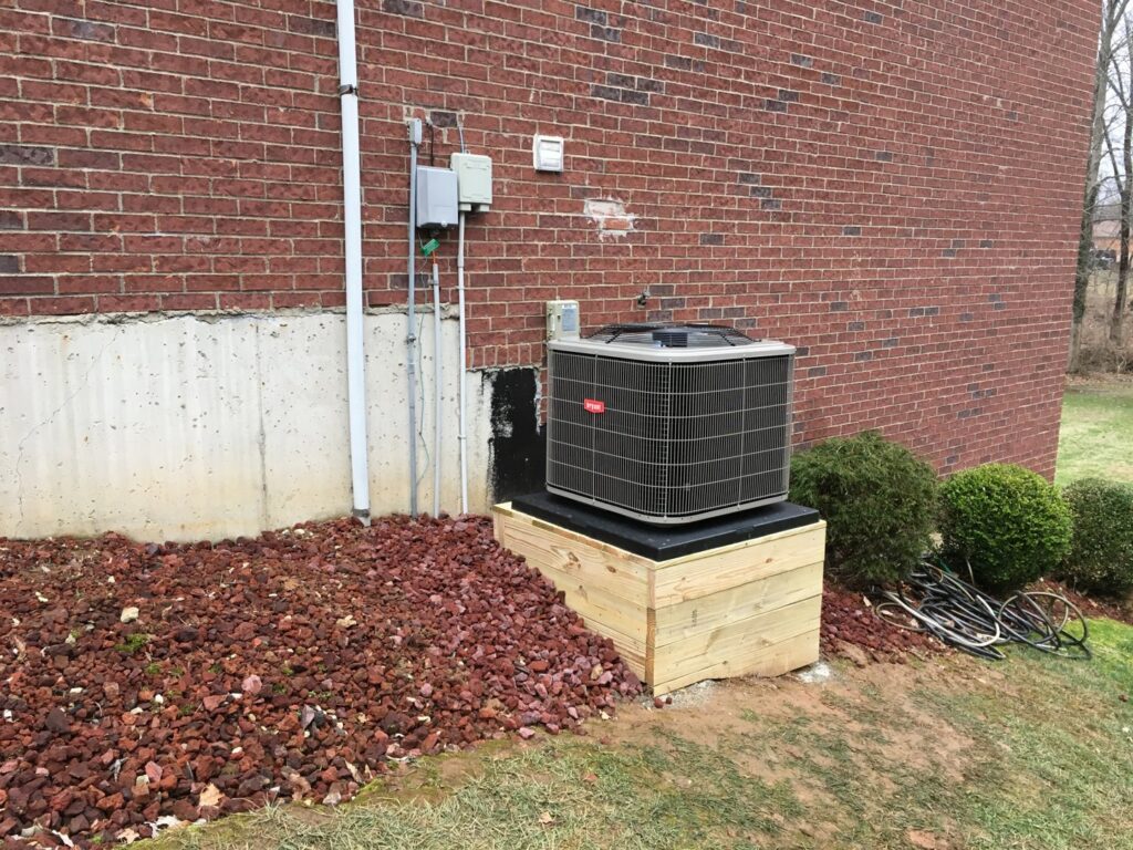 An outdoor Bryant AC unit installed on a wooden platform by Wise Heating & Air Conditioning, LLC in Louisville, KY.