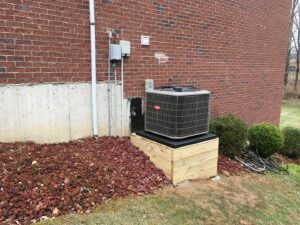 An outdoor Bryant AC unit installed on a wooden platform by Wise Heating & Air Conditioning, LLC in Louisville, KY.