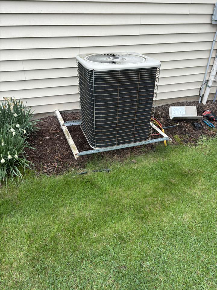 An outdoor air conditioning unit on a metal stand, serviced by Air Control Heating & Cooling LLC in Schererville, IN.