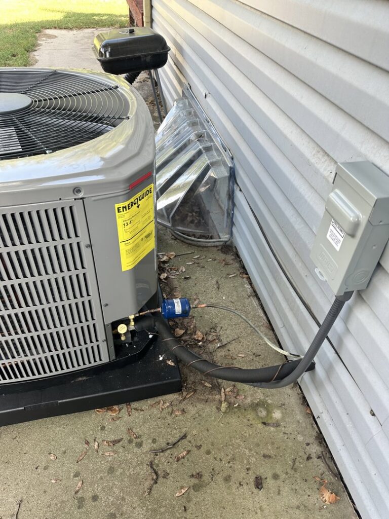 An outdoor air conditioning unit with refrigerant lines and electrical disconnect installed by Specialized Service Heat & Air in Wichita, KS.