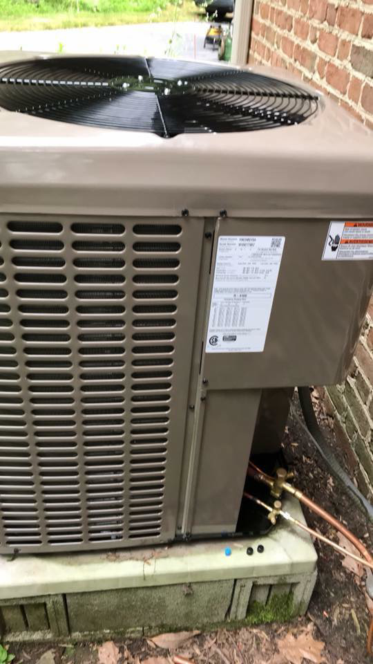 An outdoor air conditioning unit showing refrigerant lines, indicating service by Leidigh's Heating & Air Conditioning in Marysville, PA.