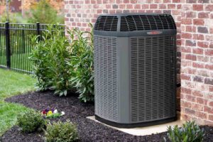 A modern outdoor air conditioning unit installed next to a residential brick home by Elite Home Comfort in Clarksville, TN