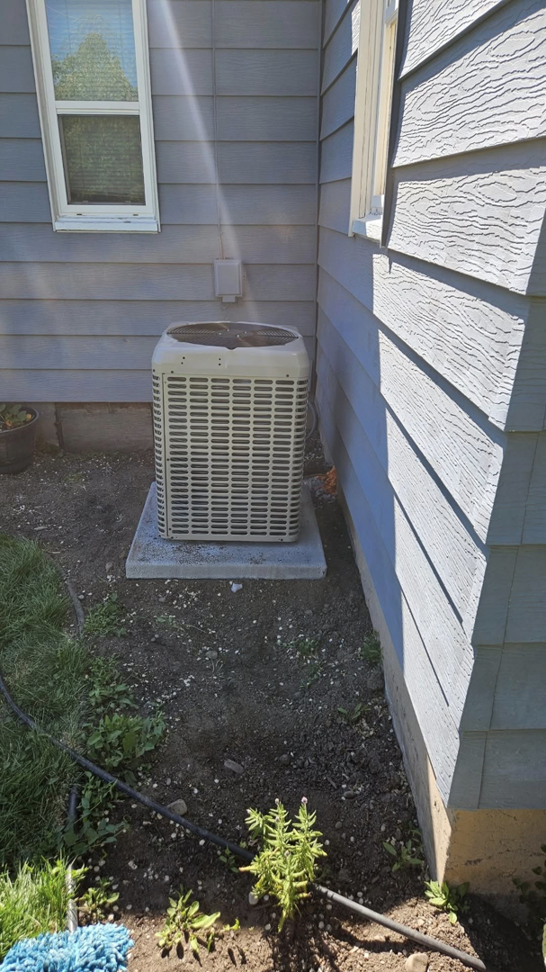 A newly installed outdoor AC unit next to a residential home by JL Mechanical in Pleasant Grove, UT.