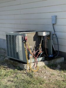 An outdoor AC unit undergoing service with refrigerant gauges connected by South Texas Climate Control in San Antonio, TX