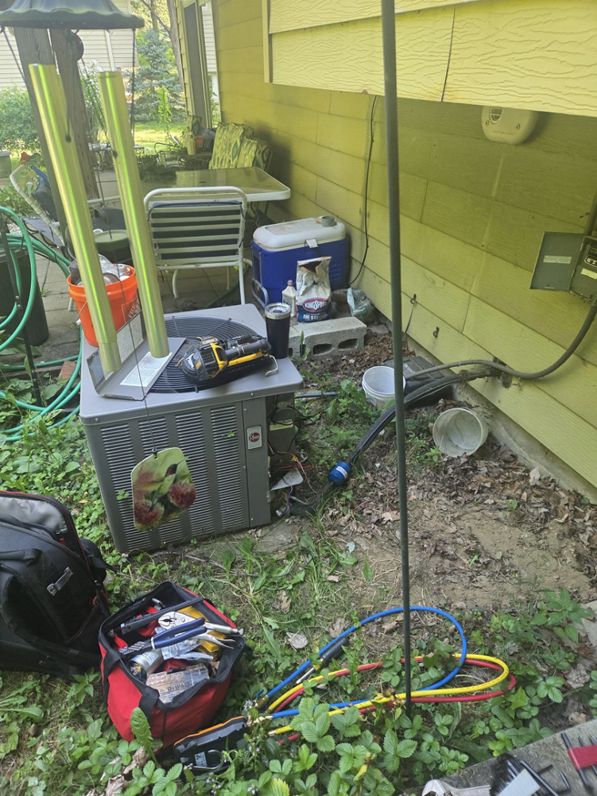 An outdoor Rheem AC unit being serviced with HVAC tools by Orchard Heating-Cooling and Sheet Metal in Stow, OH.