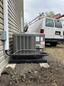 An outdoor air conditioning unit being serviced with a P3 Mechanical Heating & Cooling van in the background in Bainbridge, PA.