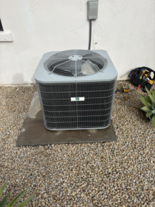 An outdoor AC unit recently serviced by Weather Masters, Inc. in Mesa, AZ, with tools nearby.