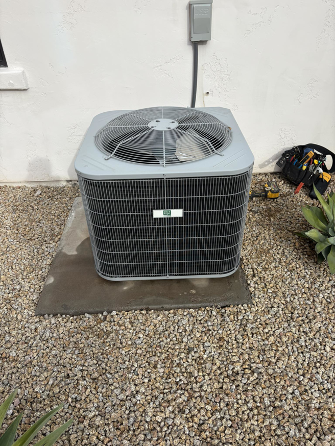 An outdoor AC unit recently serviced by Weather Masters, Inc. in Mesa, AZ, with tools nearby.