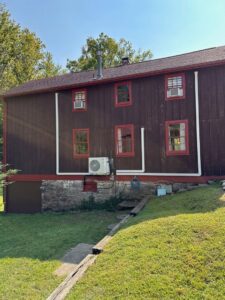 An exterior view of a building showing an outdoor AC unit and window air conditioners installed by Integrity Aire in St. Charles, MO.