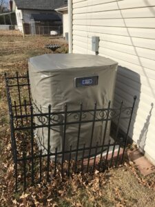 An outdoor air conditioning unit covered for winterization, installed by Epic Heating & Cooling in Wichita, KS.