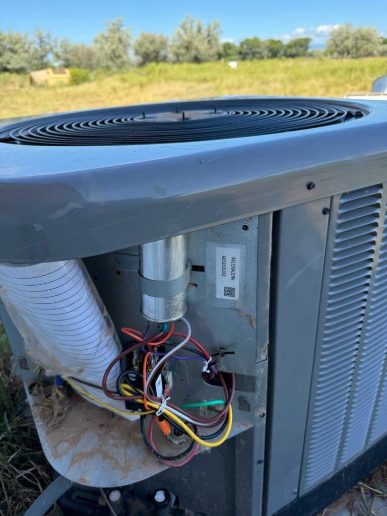 Detailed view of the wiring and components inside an outdoor AC unit, serviced by Diamond L Plumbing & HVAC in Salt Lake City, UT.